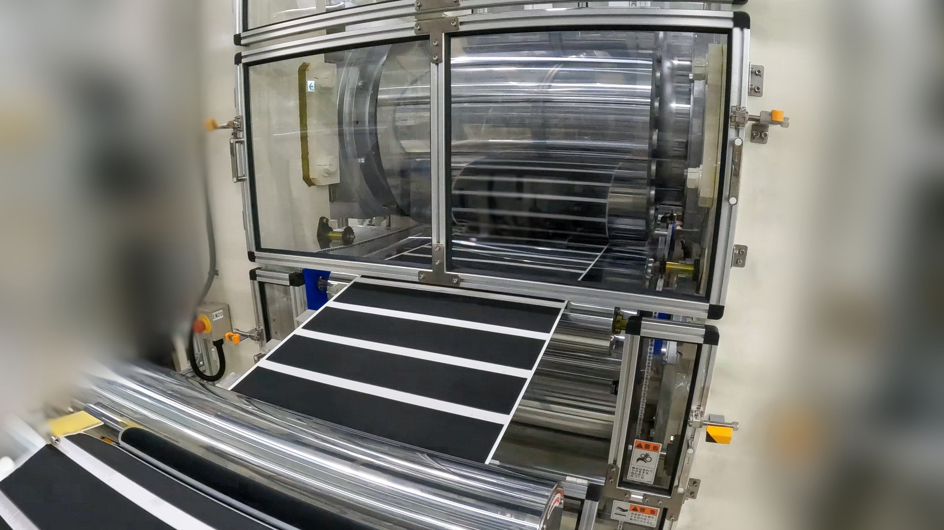 A black film feeds through roll presses in a Honda pilot factory making prototype solid-state batteries.